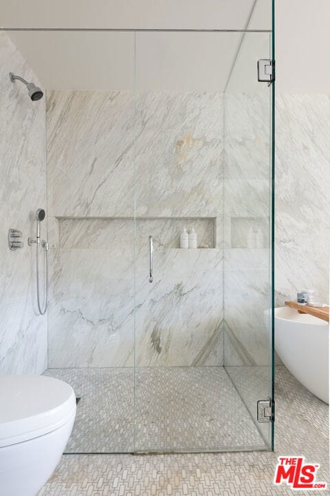 bathroom featuring walk in shower and toilet