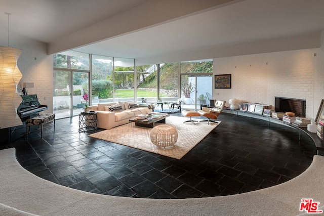 interior space featuring a brick fireplace and a wall of windows