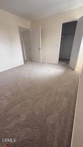 unfurnished bedroom with a closet and light colored carpet
