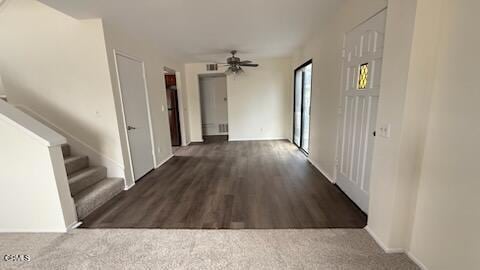 corridor with baseboards, wood finished floors, and stairway