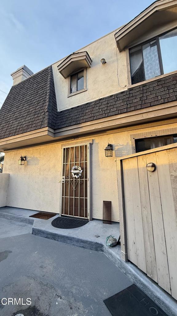 property entrance featuring roof with shingles and a chimney