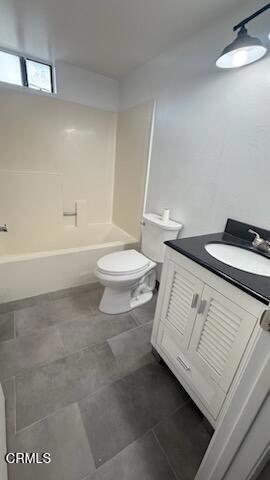 full bath featuring tile patterned floors, vanity, toilet, and  shower combination