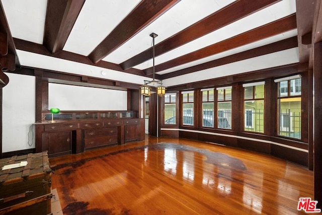 unfurnished living room featuring dark hardwood / wood-style floors and beam ceiling