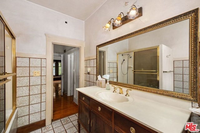 bathroom featuring tile patterned flooring, vanity, and tile walls