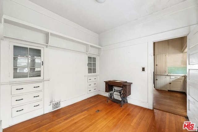 interior space with hardwood / wood-style flooring and crown molding