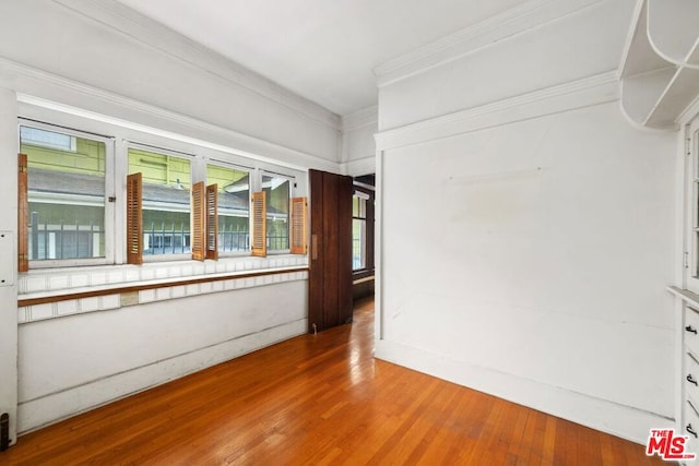 empty room featuring crown molding and hardwood / wood-style floors