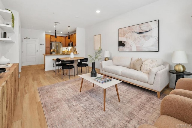 living room with sink and light hardwood / wood-style flooring