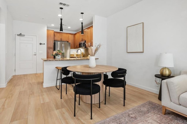 dining room featuring sink and light wood-type flooring