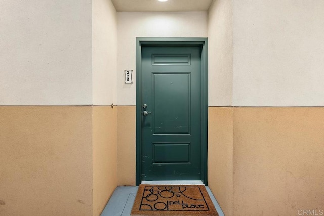 property entrance with stucco siding