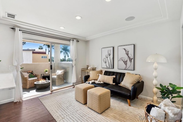 living room featuring wood-type flooring and ornamental molding