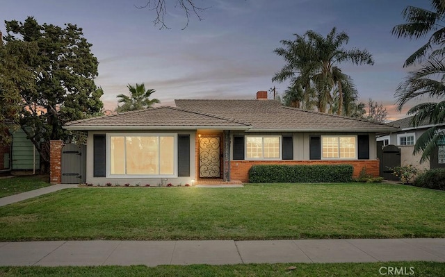 ranch-style home featuring a yard