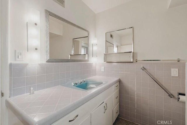 bathroom with vanity and tile walls