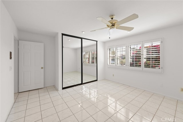 tiled spare room featuring ceiling fan