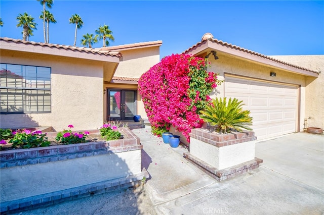 mediterranean / spanish home featuring concrete driveway, an attached garage, and stucco siding