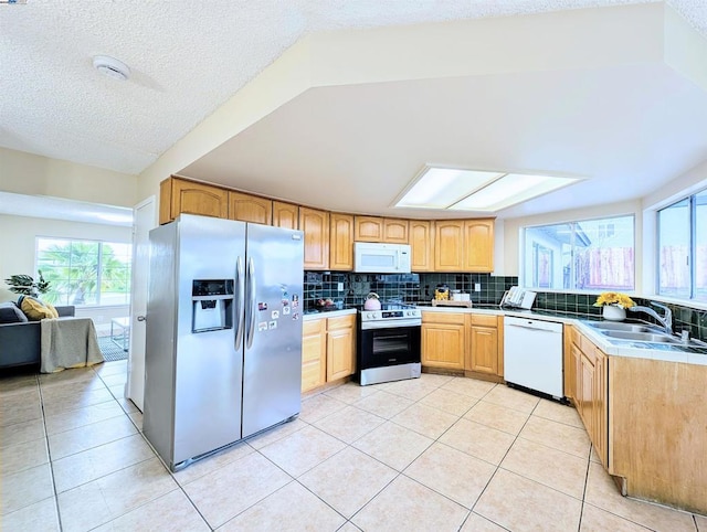 kitchen featuring light tile patterned flooring, appliances with stainless steel finishes, sink, and backsplash