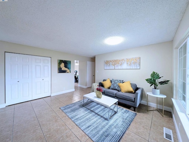 tiled living room featuring a textured ceiling