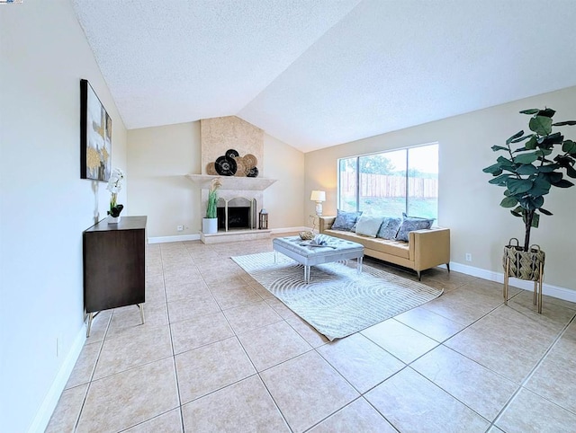 unfurnished living room with vaulted ceiling, a large fireplace, light tile patterned floors, and a textured ceiling