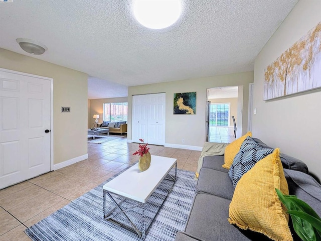 living room with light tile patterned floors, plenty of natural light, and a textured ceiling