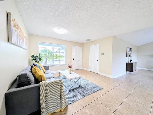 living room with a textured ceiling and light tile patterned floors