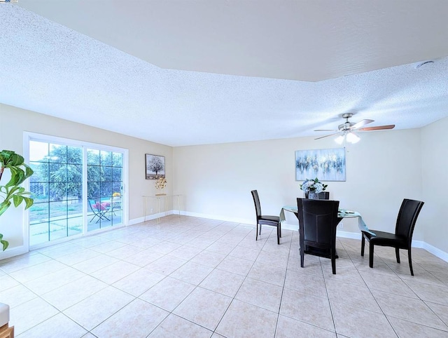 tiled dining room with ceiling fan and a textured ceiling