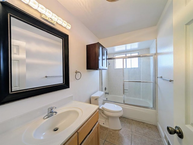 full bathroom featuring vanity, tile patterned floors, shower / bath combination with glass door, and toilet