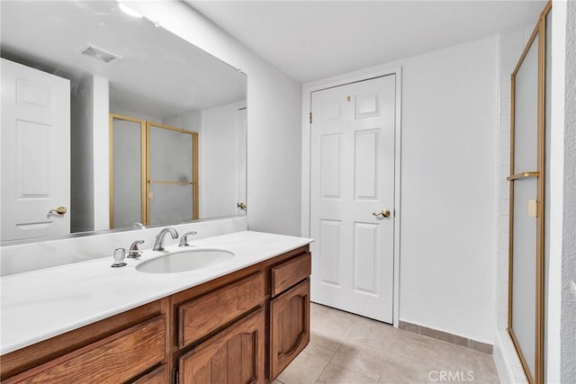 bathroom featuring vanity, tile patterned floors, and a shower with shower door