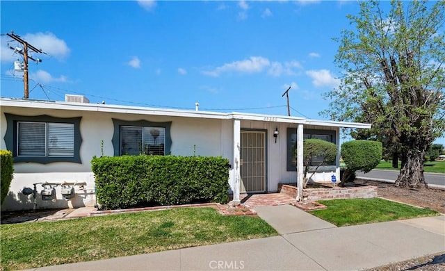 single story home with stucco siding and a front lawn