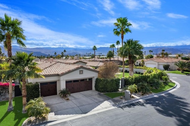 mediterranean / spanish-style home with a mountain view and a garage