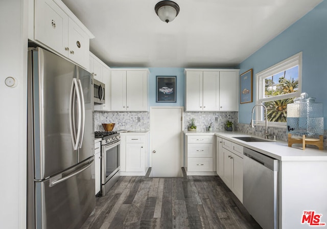 kitchen with stainless steel appliances, sink, white cabinets, and dark hardwood / wood-style flooring