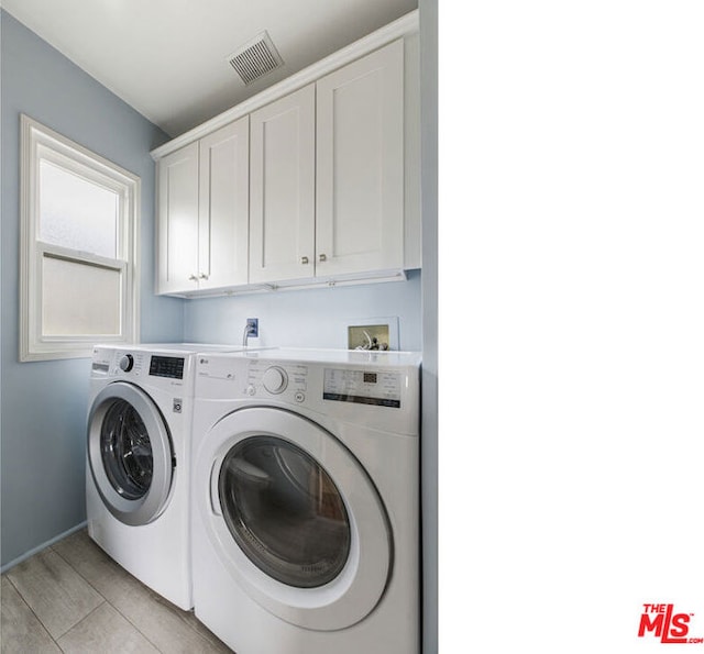 laundry area featuring cabinets, separate washer and dryer, and light tile patterned floors