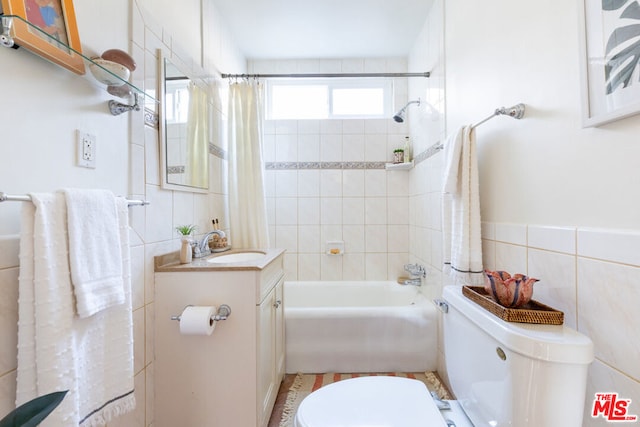 full bathroom featuring tile walls, shower / tub combo, vanity, and toilet