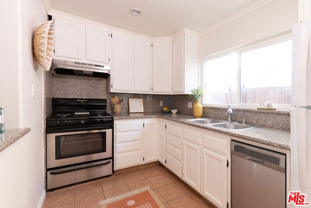 kitchen with sink, light tile patterned floors, appliances with stainless steel finishes, white cabinetry, and decorative backsplash