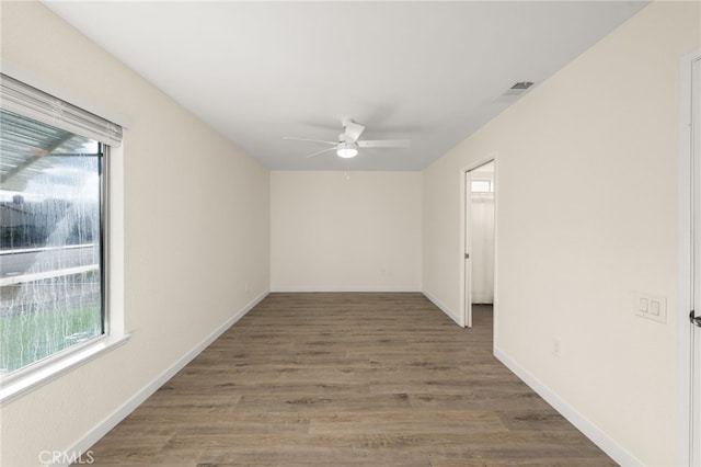 spare room featuring plenty of natural light, dark hardwood / wood-style floors, and ceiling fan