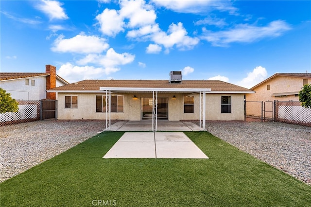 rear view of property featuring a patio and a yard