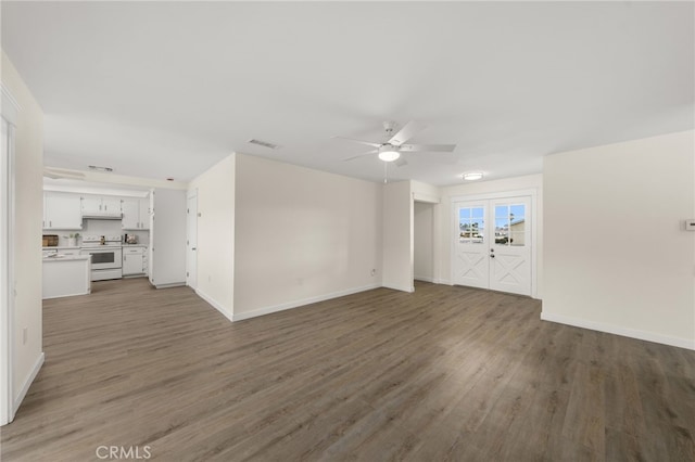 unfurnished living room featuring dark wood-type flooring and ceiling fan