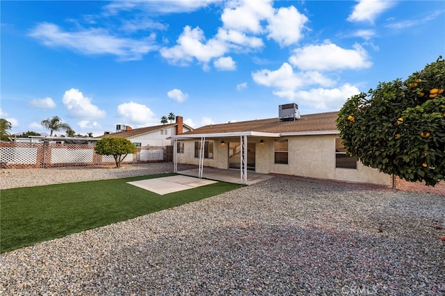 back of property featuring a patio, a yard, and central AC