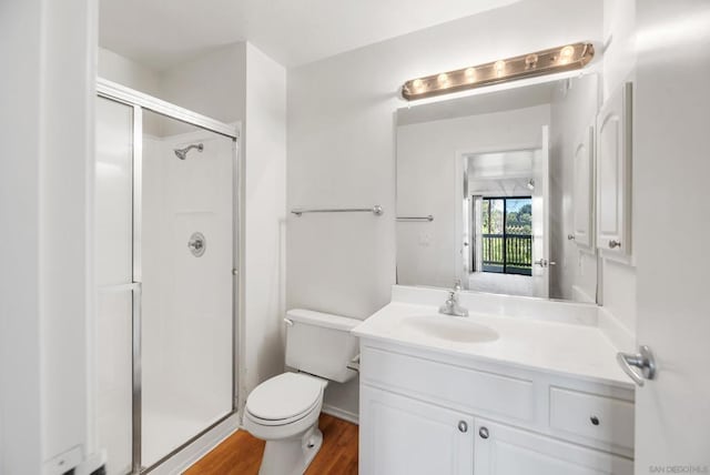 bathroom featuring vanity, hardwood / wood-style floors, an enclosed shower, and toilet