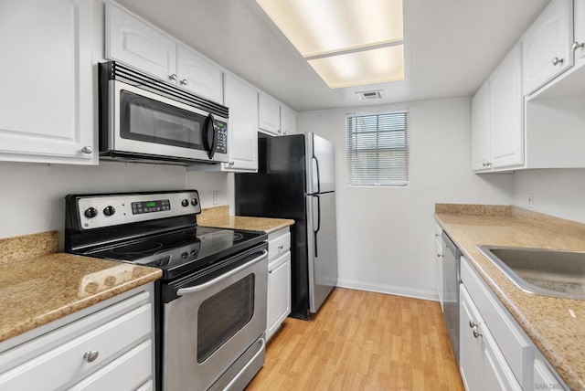 kitchen featuring white cabinetry, sink, light wood-type flooring, and appliances with stainless steel finishes