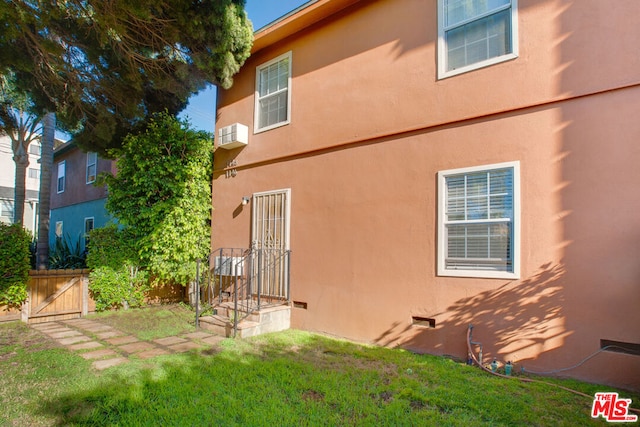 rear view of property featuring a lawn