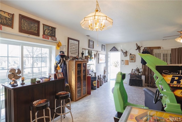 interior space with ceiling fan with notable chandelier