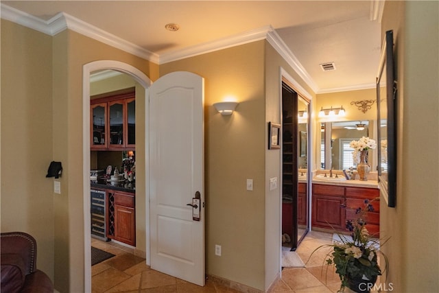 hallway with crown molding, sink, and beverage cooler