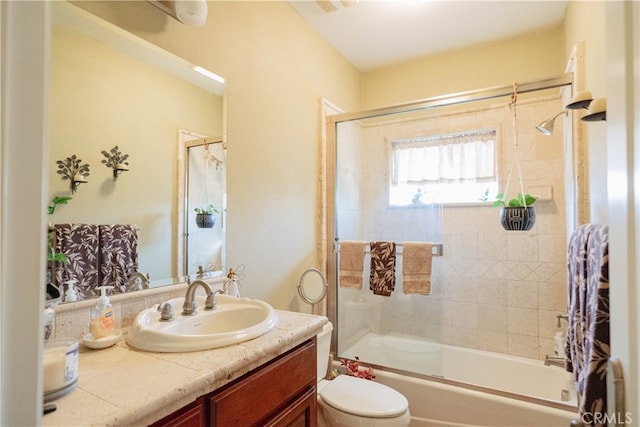 full bathroom with vanity, enclosed tub / shower combo, and toilet