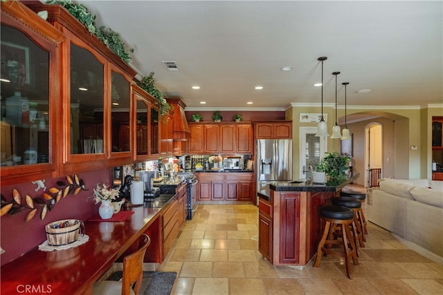 kitchen with crown molding, decorative light fixtures, custom exhaust hood, and appliances with stainless steel finishes