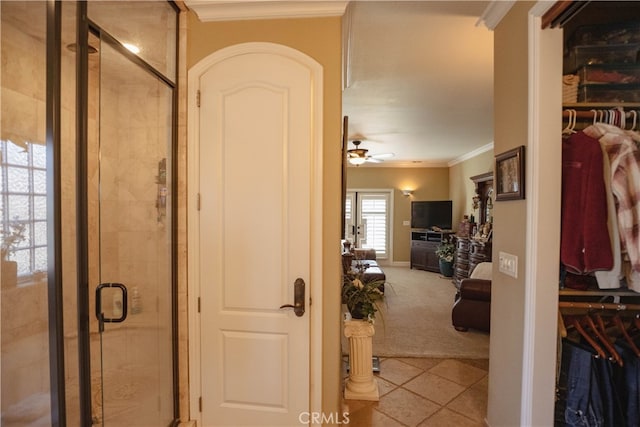 bathroom featuring tile patterned flooring, a shower with shower door, ornamental molding, and ceiling fan