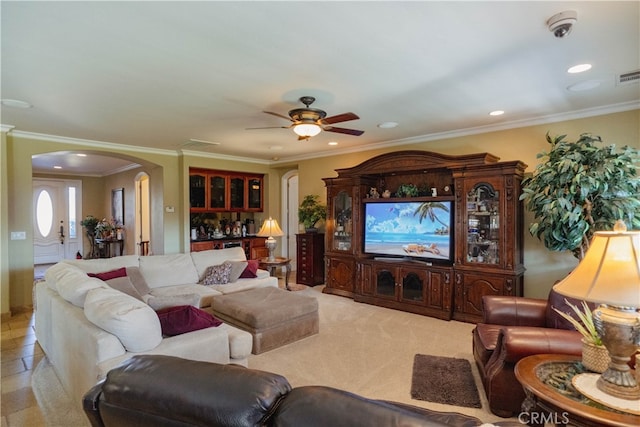 carpeted living room with crown molding and ceiling fan