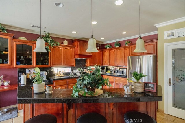 kitchen featuring decorative light fixtures, ornamental molding, and appliances with stainless steel finishes