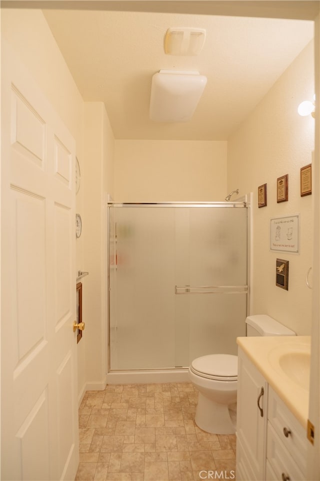 bathroom with vanity, toilet, and a shower with shower door