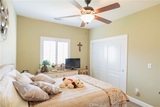 bedroom with ceiling fan, carpet, and a closet