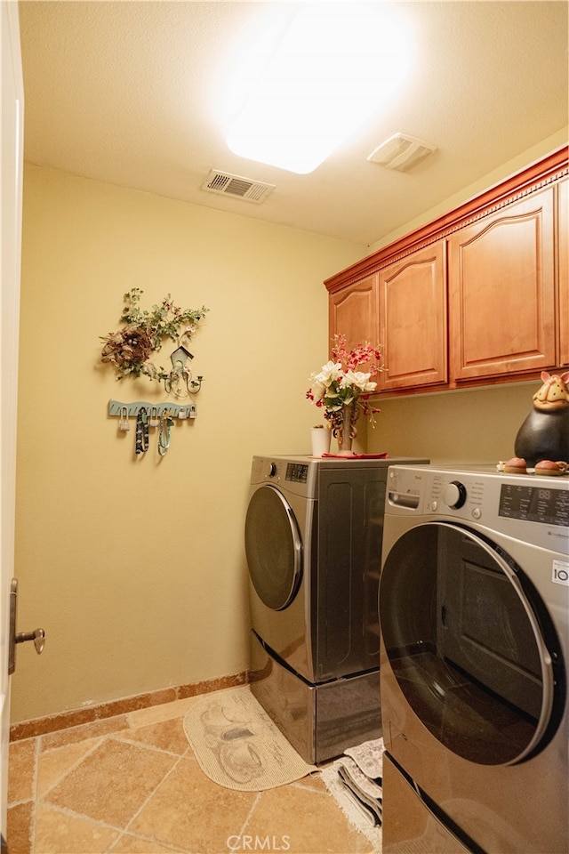 laundry room featuring cabinets and washer and dryer