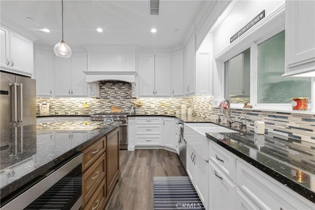 kitchen featuring white cabinetry, pendant lighting, and dark stone countertops